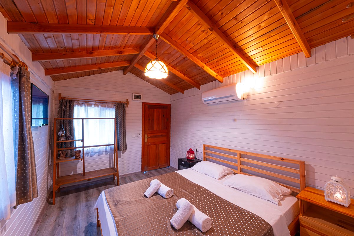 Bungalow Oda: ahşap çatı altında yatak ve avize